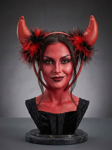 Diadema de diablesa con cuernos rojos y plumas rojas y negras sobre una cabeza de exposición