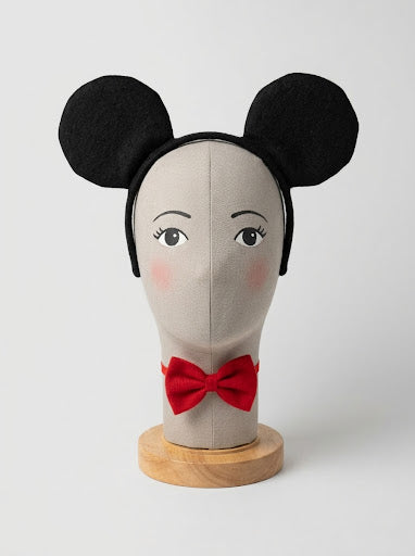 Diadema negra con dos orejas redondas de Minnie Mouse sobre un soporte de exposición