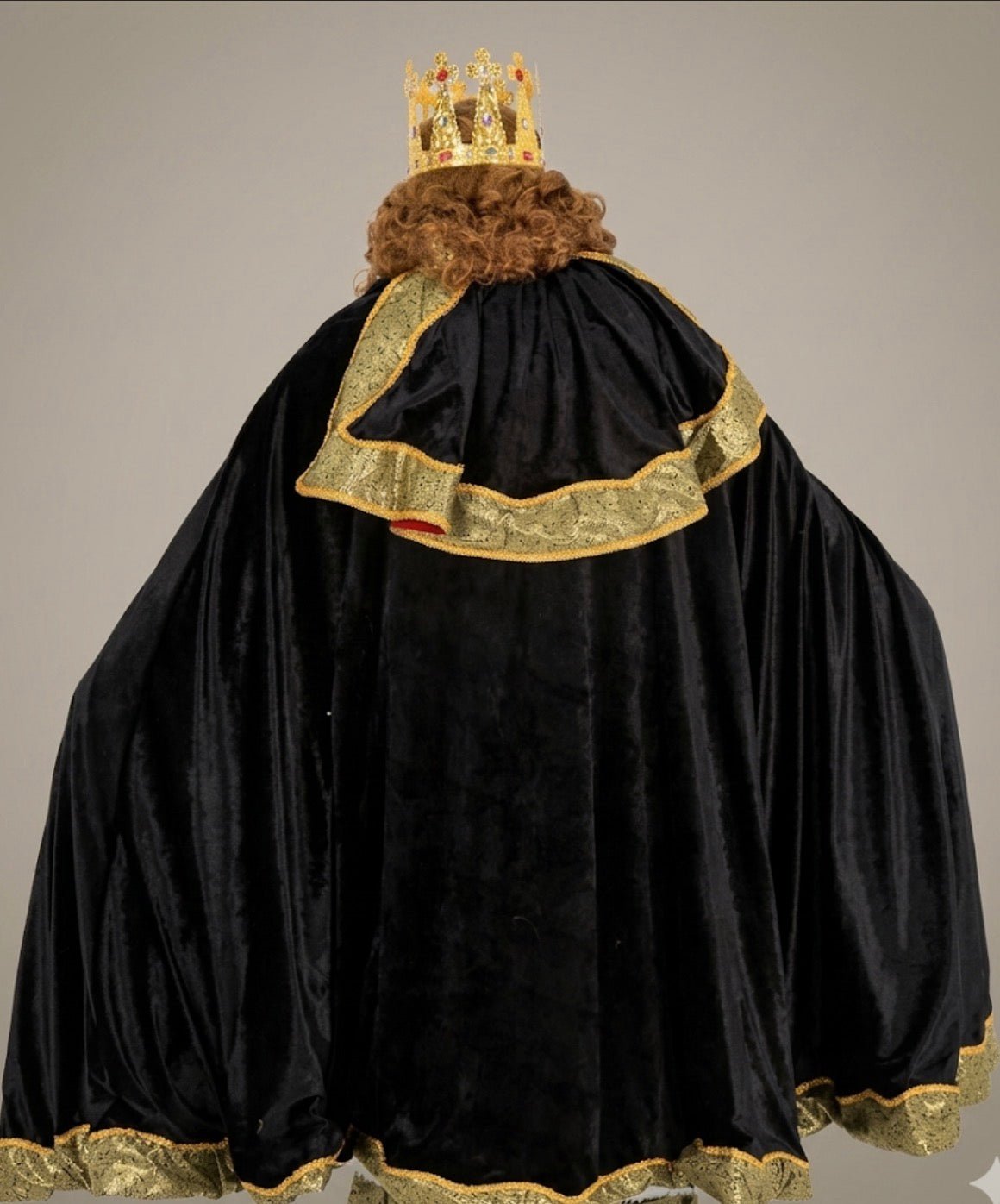 Capa trasera del traje de rey negra con ribete dorado y falda aterciopelada