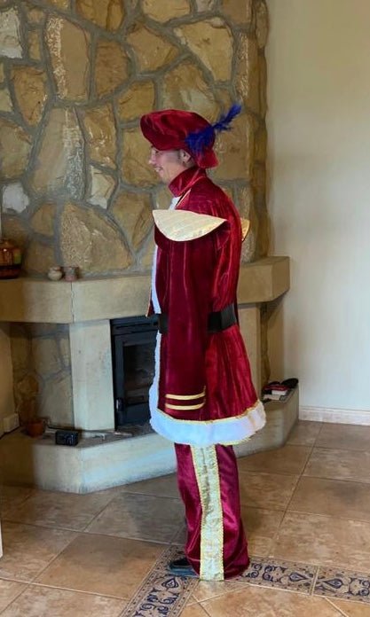 Traje de Rey Melchor burdeos con abrigo largo, gorro rojo con pluma azul y pantalón a juego