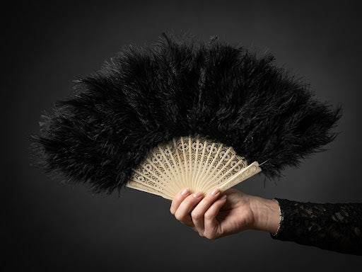 Abanico abierto de plumas negras con varillaje claro calado, de 50 cm abierto