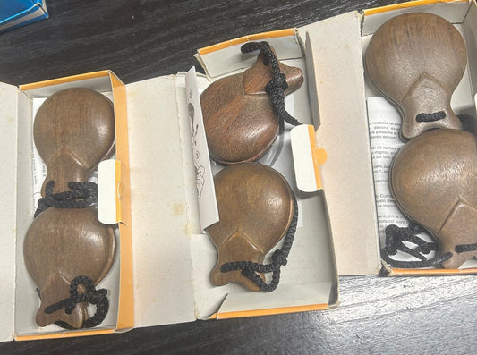 Castañuelas de madera marrón con detalles negros, en estuche abierto