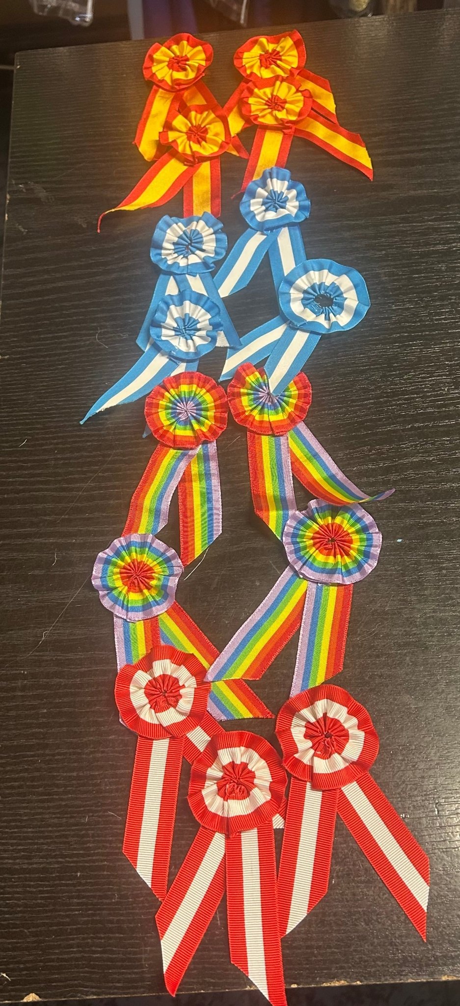 Escarapela con cintas tricolor y rosetones: rojo, azul y verde, con moños y apliques