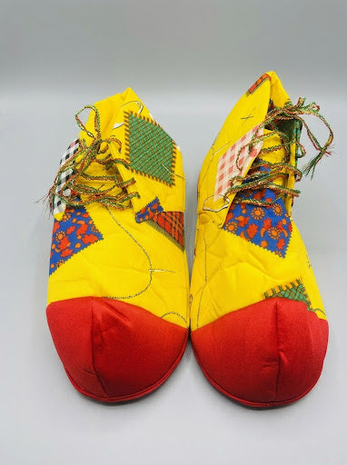Zapatos de payaso amarillos con puntera roja y parches de colores, cordones