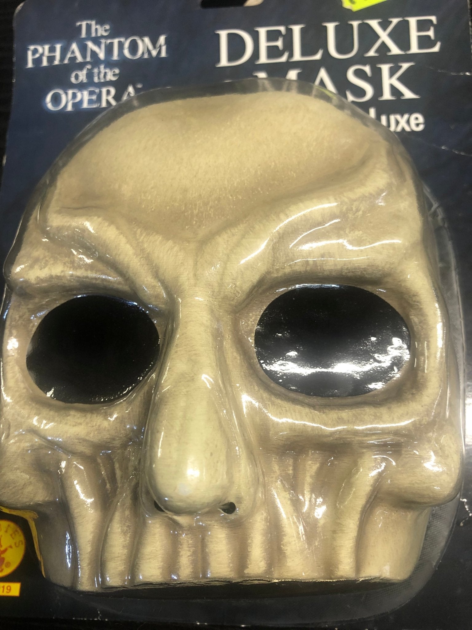 Máscara de calavera dorada con ojos negros y contorno brillante
