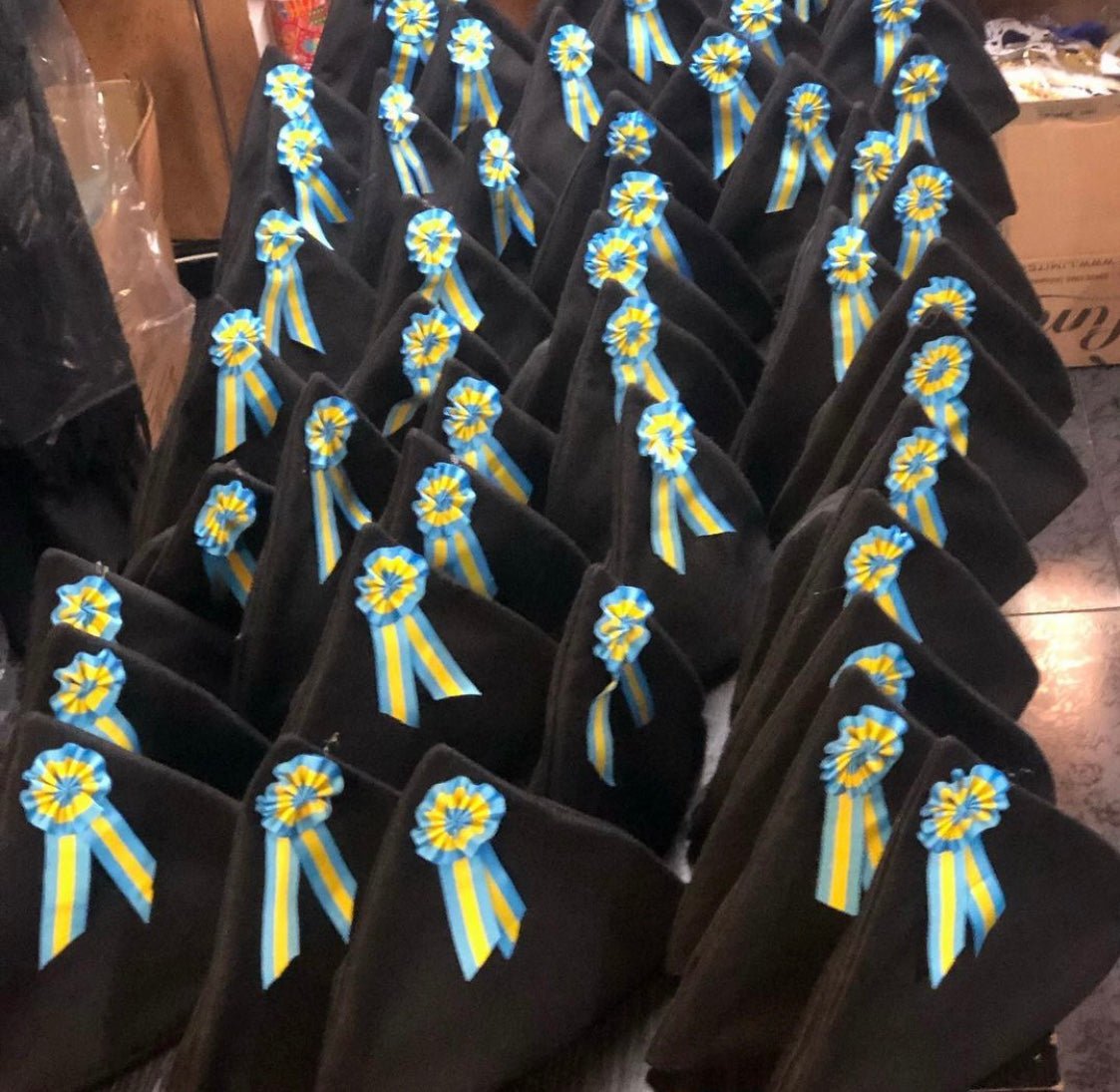 Gorros triangulares negros con escarapela azul y amarilla bordada