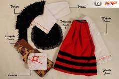 Conjunto regional con blusa blanca, chaleco negro y falda roja a rayas